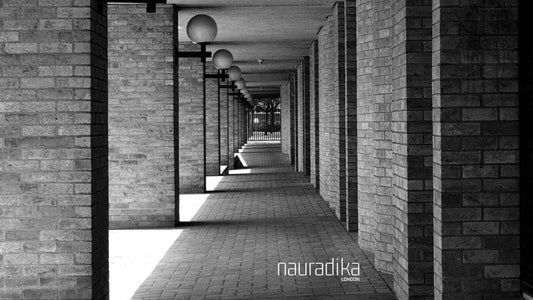 What impact did Le Corbusier have on interior design? Modern architectural corridor with brick walls and columns.