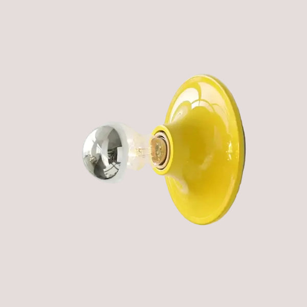 80s revival wall light in vibrant yellow UFO shape with silver bulb, perfect for retro-inspired decor.