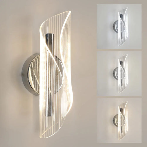 Chrome ribbon LED wall light with a twisting clear acrylic shade and polished chrome stem, lit against a warm beige wall
