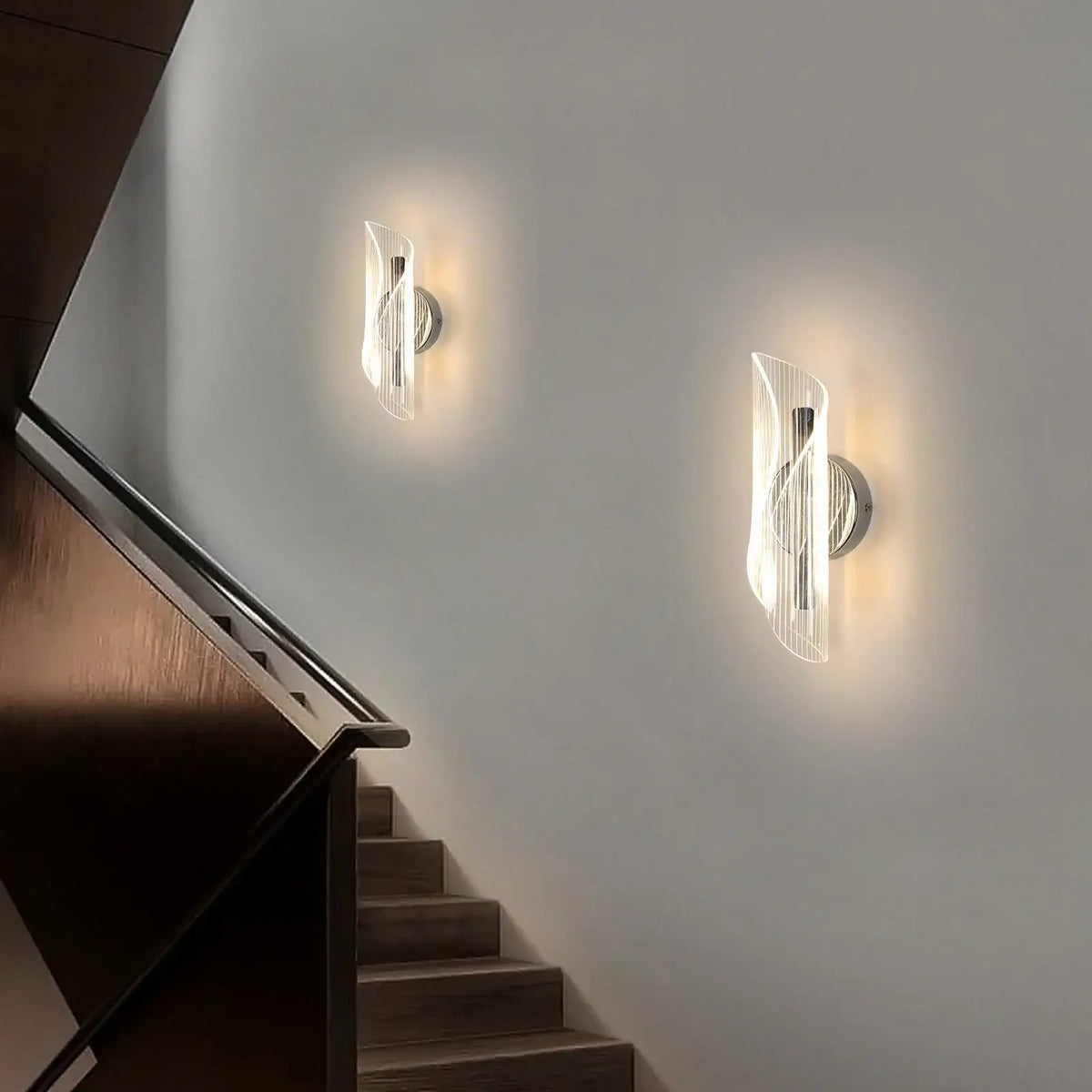 Contemporary chrome ribbon LED wall lights on a staircase wall