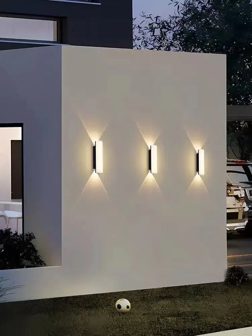 Aluminum Outdoor Modern Nordic Dimmable Wall Lamp illuminating a white wall in a contemporary outdoor setting.