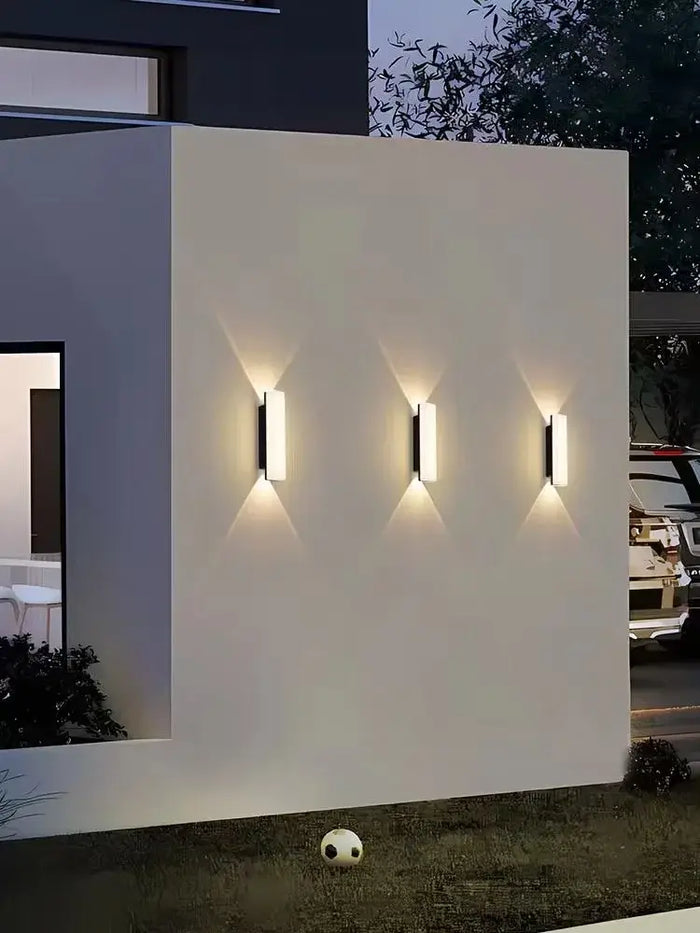 Aluminum Outdoor Modern Nordic Dimmable Wall Lamp illuminating a white wall in a contemporary outdoor setting.