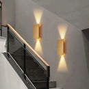Brushed Gold/Black Double Head Wall Light illuminating a modern staircase with warm light.
