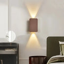 Brushed Gold/Black Double Head Wall Light illuminating a modern bedroom with warm light.