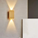 Brushed Gold/Black Double Head Wall Light illuminating a minimalist interior wall.