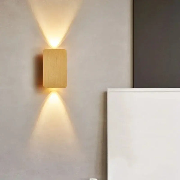 Brushed Gold/Black Double Head Wall Light illuminating a minimalist interior wall.