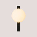 Decorative Lighting Fixture With Milk White Glass Sphere mounted on a black wall.