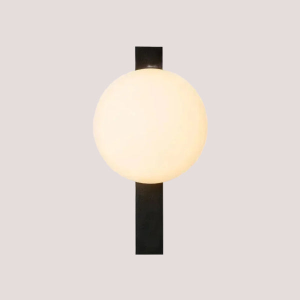 Decorative Lighting Fixture With Milk White Glass Sphere mounted on a black wall.