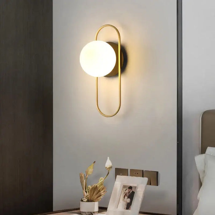 Art Deco Golden Circle Sconce illuminating a modern bedroom with a stylish design and warm ambiance.
