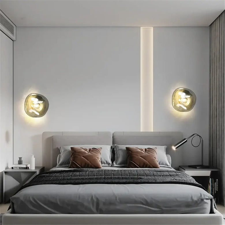 Lava Glass Wall Lamp illuminating a stylish modern bedroom with elegant decor and cozy bedding.
