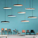 Minimalist Metal Hanging Lamp in various colors suspended in a modern space with stylish chairs.