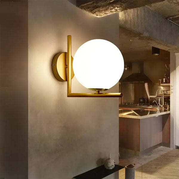 Gold Wall Light with white ball and gold structure, enhancing modern interior decor in a stylish setting.