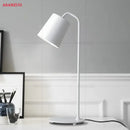 White metal desk lamp with minimalist design on a desk, ideal for modern office decor.