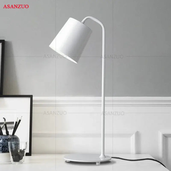 White metal desk lamp with minimalist design on a desk, ideal for modern office decor.