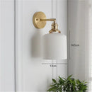 Timeless Elegance: Nordic White Porcelain Wall Lamp mounted on wall with gold hardware, showcasing soft ambient lighting.