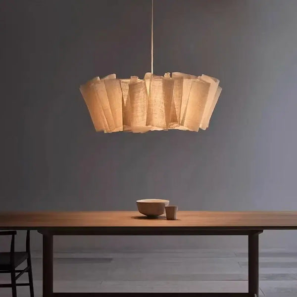 Off-White Pendant Light made from Natural Plant Fiber hanging above a wooden dining table with minimal decor.