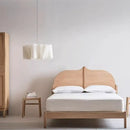Off-White Pendant Light made from Natural Plant Fiber hanging over a cozy wooden bed in a minimalist bedroom.