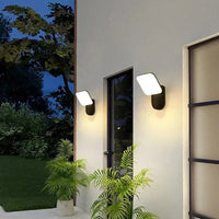 Modern Simple LED Outdoor Wall Lamp illuminating a stylish home entrance with greenery.