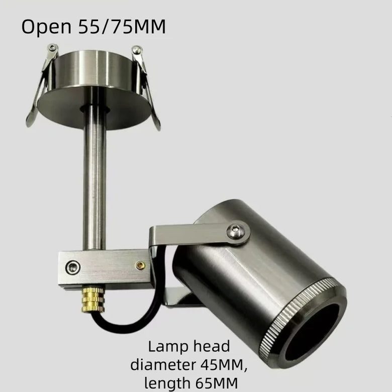 A stainless steel adjustable spotlight fixture with a cylindrical lamp head, mounting bracket, and ceiling canopy, shown on a light gray background with text overlays indicating dimensions.