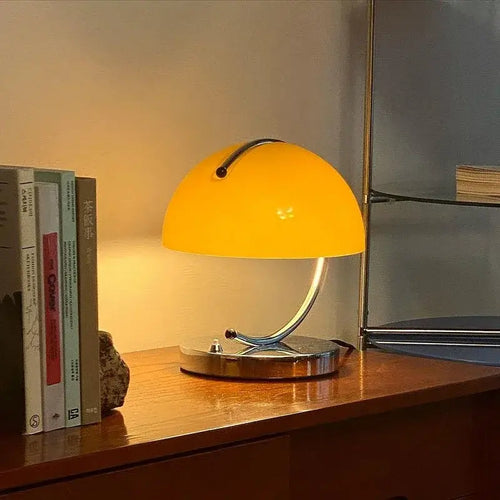 80s USB desk lamp in various colours with a yellow shade on a wooden desk.