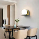 Chic Modern Sconce Collection – Illuminate with Style on a dining room wall with glass and iron design.