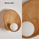 Resin Wall-Mounted Bathroom Light in brown color with frosted glass globe for modern interior design.