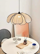 Black and White Rattan Flower Lamp Shade hanging over a minimalist white table in a bright room.