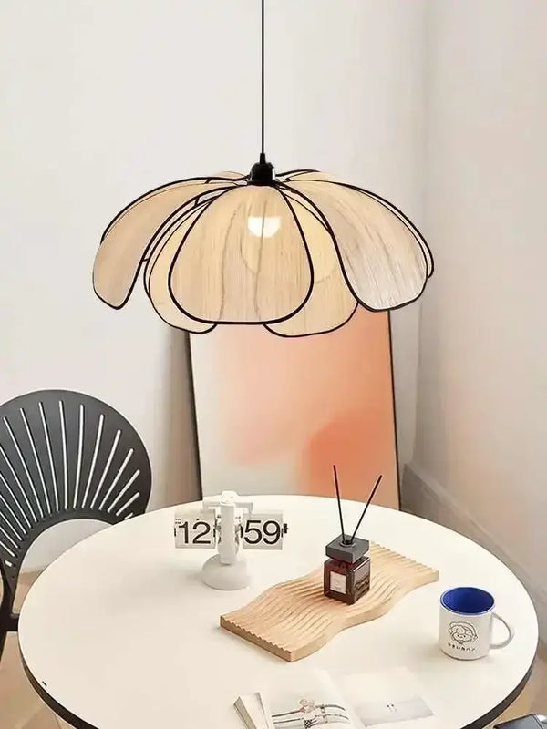 Black and White Rattan Flower Lamp Shade hanging over a minimalist white table in a bright room.