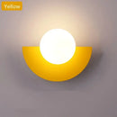 Halfmoon Metal Sconce in yellow color, featuring a round LED light, showcasing Nordic design.