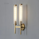 Stylish Art Deco Brass Wall Lamp featuring frosted glass and a warm white glow on a modern wall.