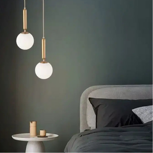 Mid-Century Modern Glass Ball Pendant Light above a stylish bed in a modern bedroom setting.