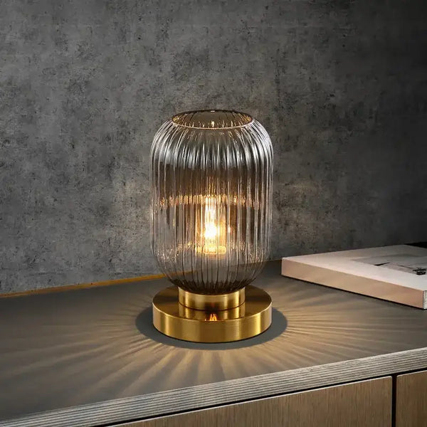 Modern Nordic Glass Table Lighting Fixtures with smoky gray glass and gold base on a tabletop.