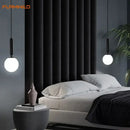 Mid-Century Modern Glass Ball Pendant Light hanging above a stylish bed in a contemporary bedroom setting.