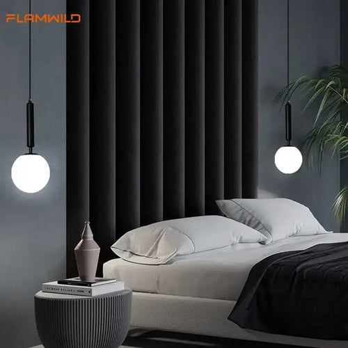 Mid-Century Modern Glass Ball Pendant Light hanging above a stylish bed in a contemporary bedroom setting.