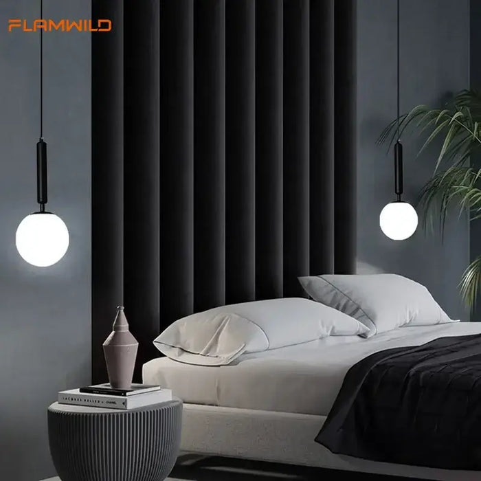 Mid-Century Modern Glass Ball Pendant Light hanging above a stylish bed in a contemporary bedroom setting.