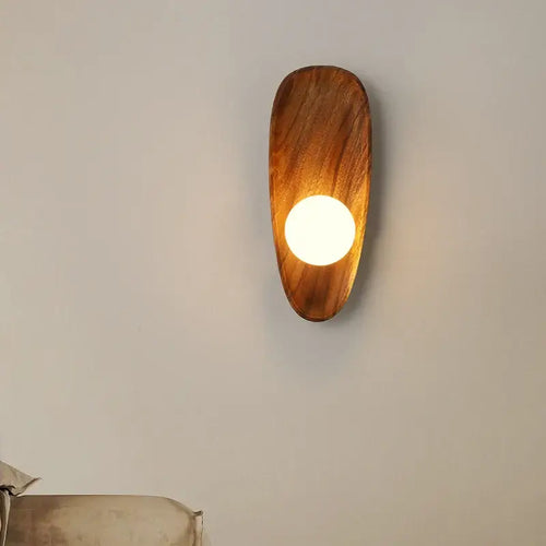 Vintage Walnut Wall Light mounted on a wall, featuring a round LED light and a sleek walnut wood design.