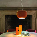 Modern Glass Pendant Light – Italian-Inspired LED Suspension Lamp in orange, illuminating a stylish dining table.