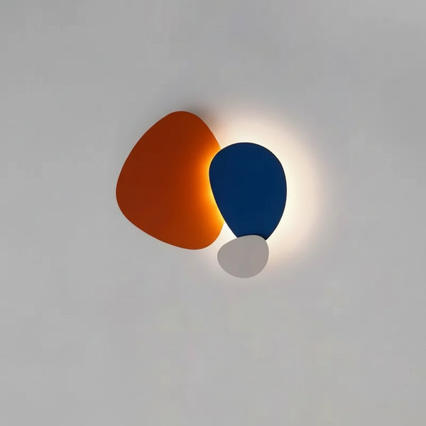 hero Modern wall light fixture with orange and blue shades on a gray wall.