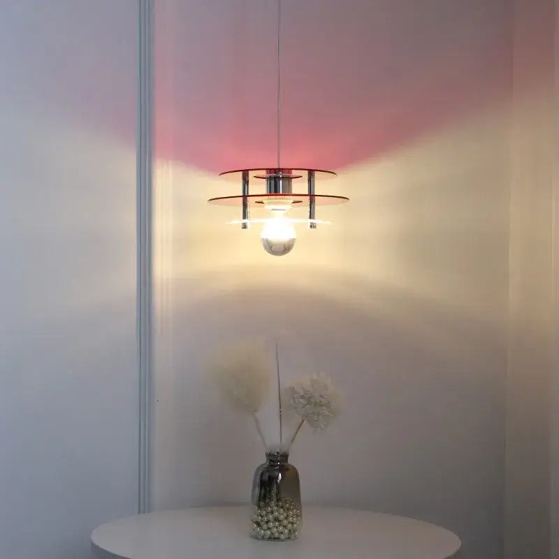 Space Age Acrylic Colorful Pendant Light hanging above a table, casting vibrant colored shadows on the wall.