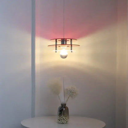 Space Age Acrylic Colorful Pendant Light hanging above a table, casting vibrant colored shadows on the wall.