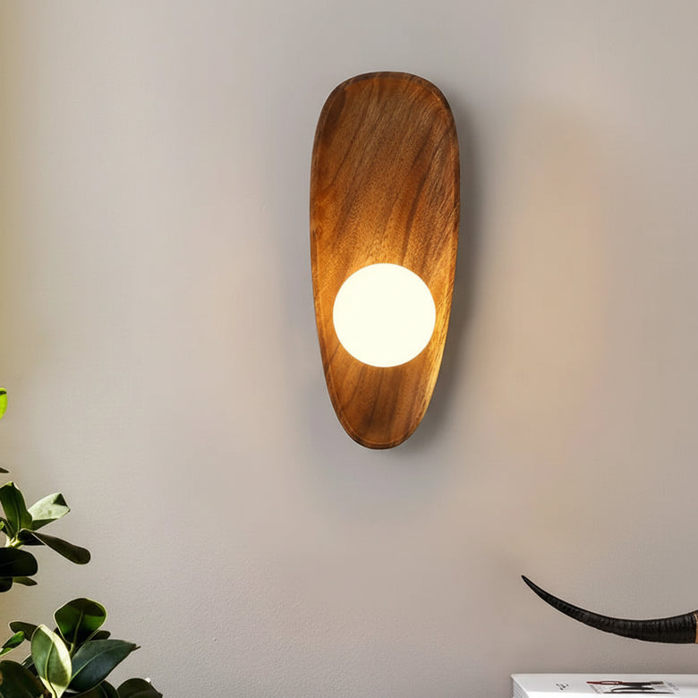 Hero Wooden wall sconce with a light bulb on a plain wall, next to a plant.