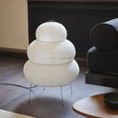 Japanese White Rice Paper Table Lamp with unique design on a wooden floor beside a couch.