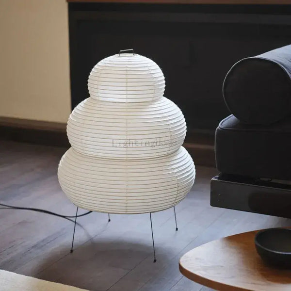 Japanese White Rice Paper Table Lamp with unique design on a wooden floor beside a couch.