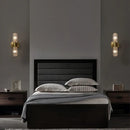 Radiant Luxe Gold Wall Sconce illuminating a modern bedroom with elegant design and warm lighting.