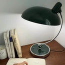 Bedside Table Lamp - Timeless Design and Modern Functionality on a wooden desk with books and a candle.