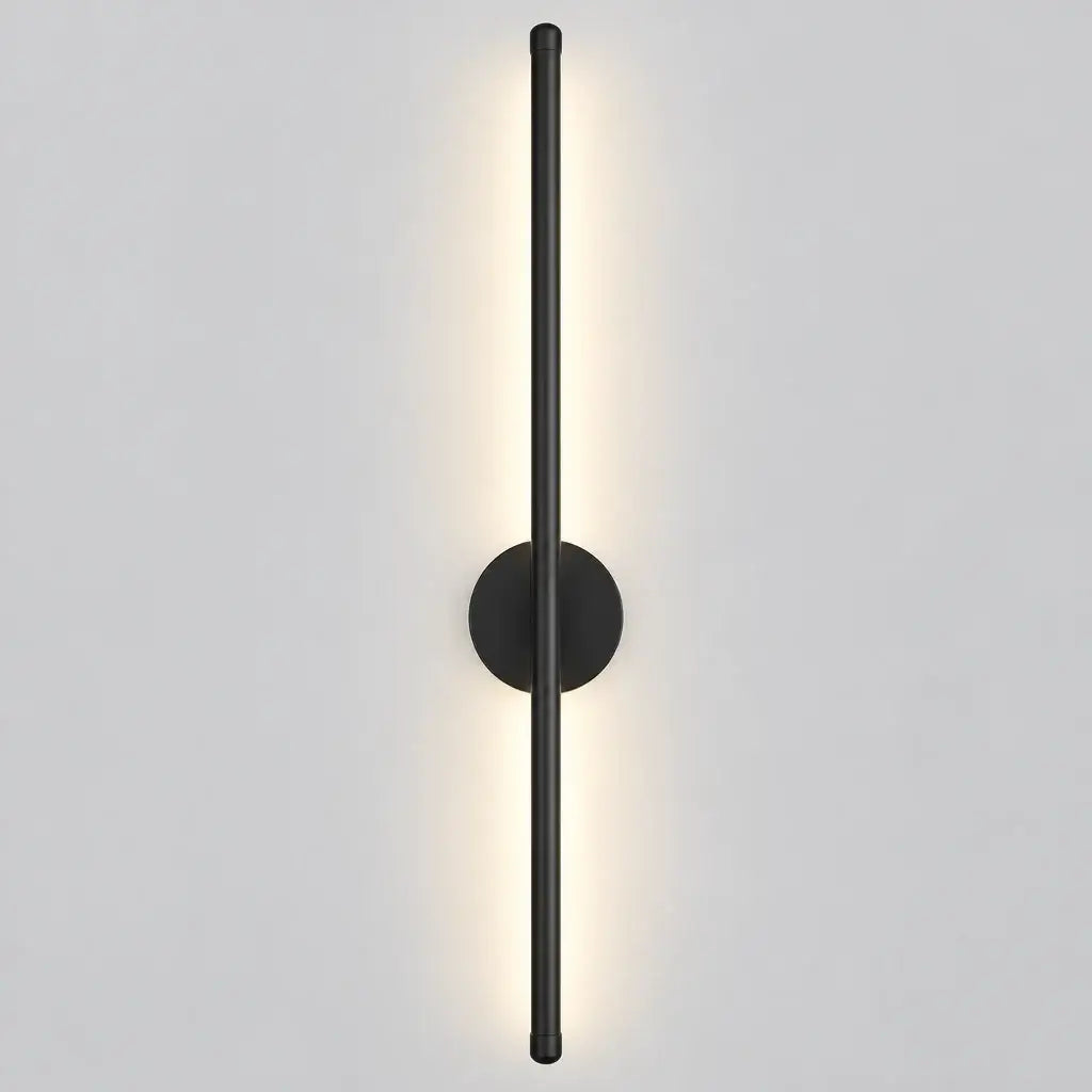 Three-tone wall sconce light fixture with a slim vertical aluminum pole, round backplate, and warm white LED illumination, shown beside product text and a small remote control on a light gray background.