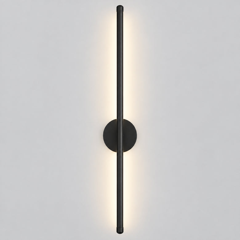 Three-tone wall sconce light fixture with a slim vertical aluminum pole, round backplate, and warm white LED illumination, shown beside product text and a small remote control on a light gray background.