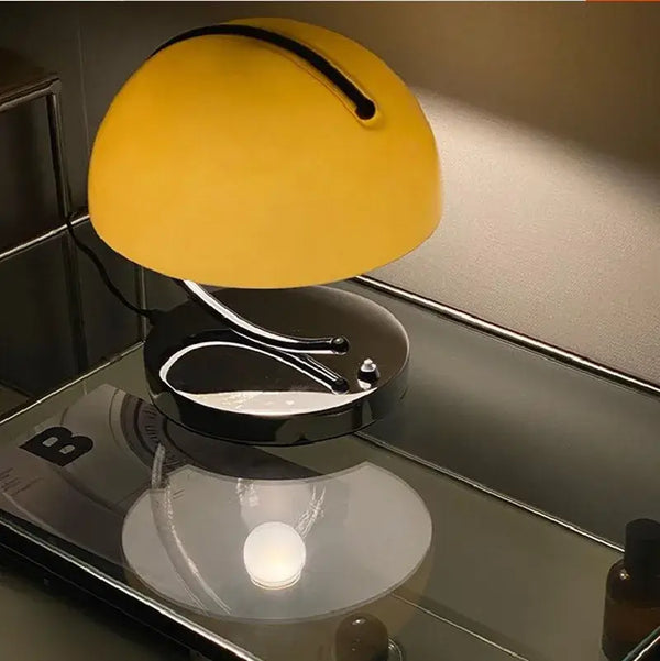 80s USB desk lamp in various colours with a yellow shade, chrome base on a reflective surface.