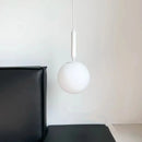 Modern Gold Glass Ball Pendant hanging elegantly above a black sofa, showcasing stylish interior lighting.
