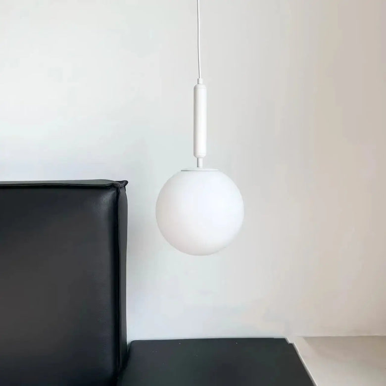 Modern Gold Glass Ball Pendant hanging elegantly above a black sofa, showcasing stylish interior lighting.